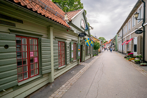 A street in in the city of Västervik, Sweden, with old wooden houses in different colors.