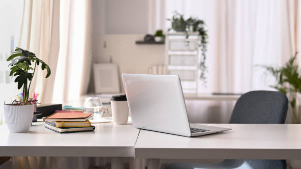 intérieur de bureau moderne et lumineux avec ordinateur portable, plantes d’intérieur, livres et diverses fournitures de bureau sur table blanche. - desk photos et images de collection