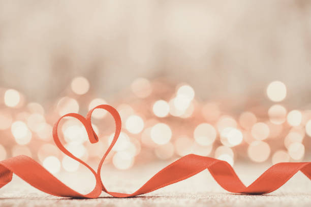 Valentine's Day background with red heart and ribbon on white background with copy space