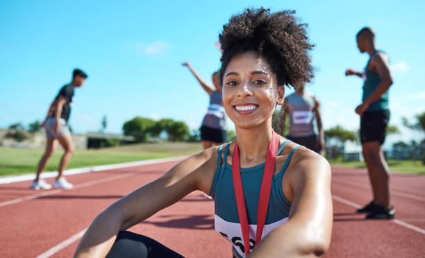 Fitness, sport and running by woman relax after marathon run outdoors at a track, happy and excited about medal. Success, winner and black girl portrait after sprint race outdoor, relax and cheerful fitness, deporte y correr por la mujer se relajan después de correr maratón al aire libre en una pista, feliz y emocionada por la medalla. Éxito, ganador y retrato de chica negra después de la carrera de sprint al aire libre, relajado y alegre