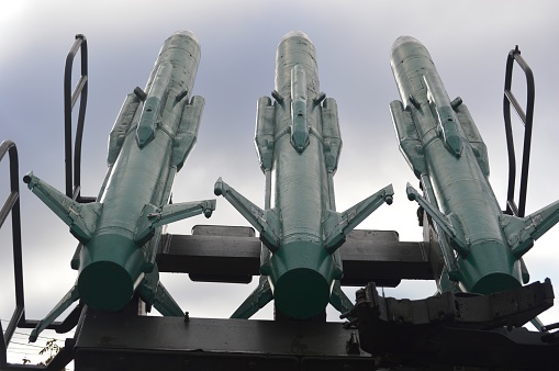 The forward turret and 5 inch Mk45 Mod 2 automatic rapid fire gun of HMAS Arunta, a frigate of the Royal Australian Navy.  Also visible are the canisters of her anti-ship missiles.  A red kangaroo insignia is visible on the cap covering the gun barrel.  She is docked at Garden Island, Sydney Harbour in preparation for an open day to the public during Navy Week, the first open day since the Covid pandemic.  This image was taken on a sunny afternoon from Woolloomooloo Bay on 25 February 2023.