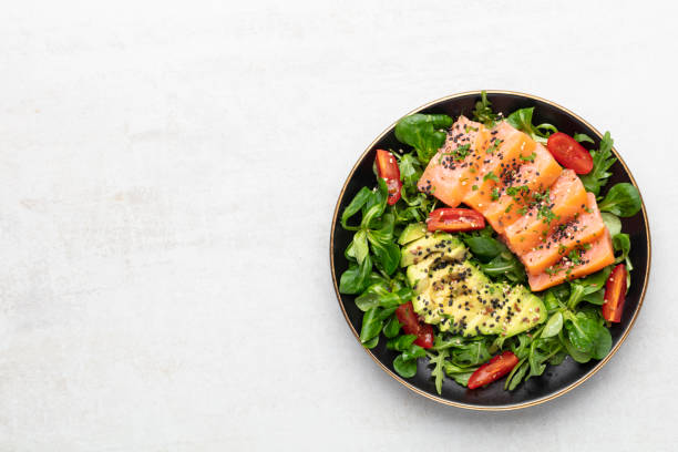 istock Salmon fish fillet with fresh salad, avocado top view. 1433059901
