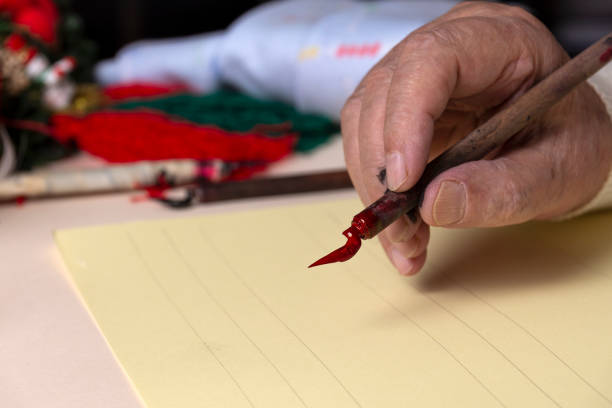 赤いインクのペンのクローズアップ。手書きによる英語書道の概念。 - inoki antonio ストックフォトと画像
