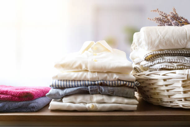 istock Clean clothes folded on a wooden shelf in a room 1433060355