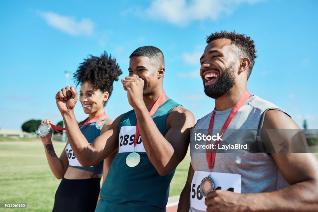 Podium, sports winner and happy people together celebrate winning race success, victory and medal. Motivation, celebration and happiness of champion young athlete team smile celebrating achievement Winning Stock Photo
