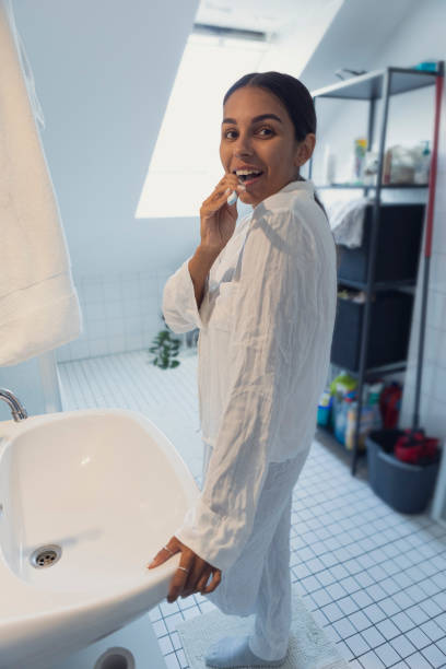 istock Woman brushing teeth and looking in mirror at home 1433063734