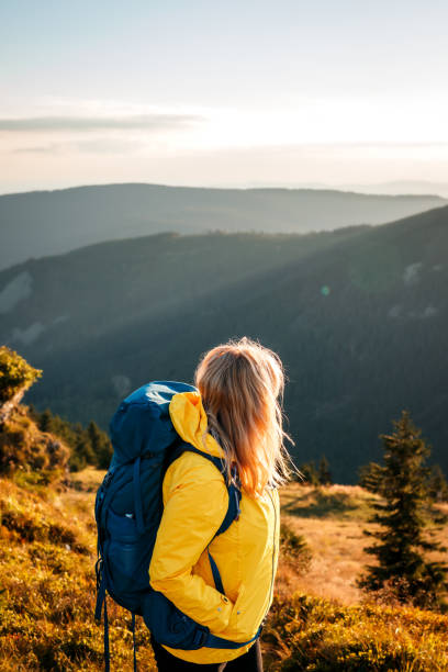 istock Woman with backpack hiking in mountains during sunset at autumn 1433064072