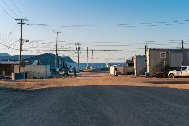 Golden hour in Inuit community of Qikiqtarjuaq, Broughton Island, Nunavut, Canada. Settlement in the far north. Arctic community. Power lines and poles. Houses on permafrost. stock photo