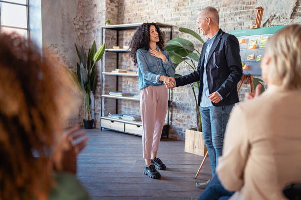 A male entrepreneur congratulates with his female partner on achieving results with handshake stock photo