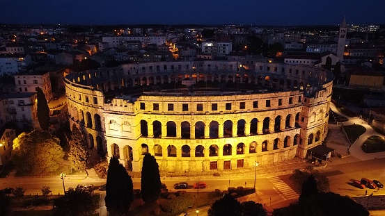 An aerial view of the illuminated Colosseum at night in Rome, Italy