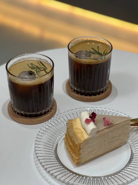 istock Piece of cake and two cocktails on white table 1433067945