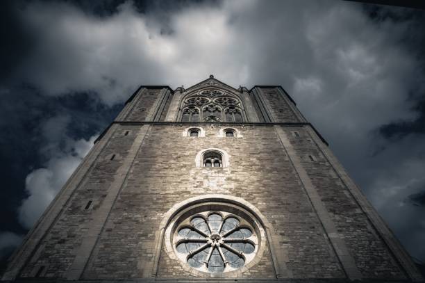 A low angle shot of an old cathedral against a cloudy sky