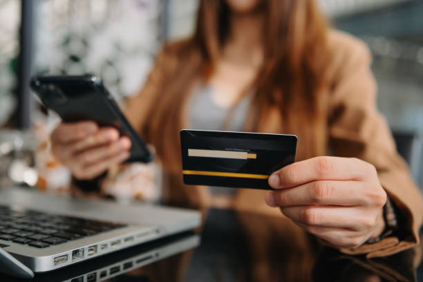istock Hand holding credit card and using tablet ,laptop,online banking payment communication network, internet wireless application 1433068675