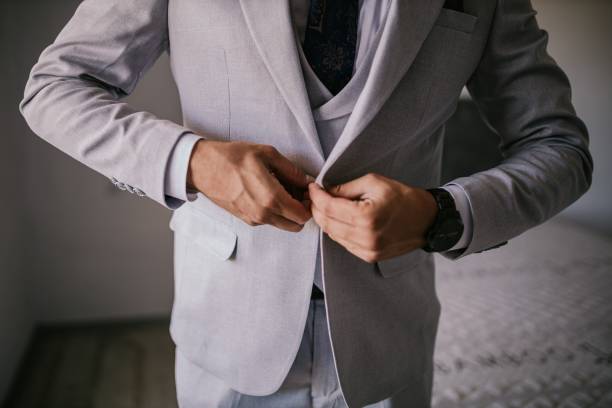 istock Man fastening a button on his light gray suit in the bedroom 1433069072