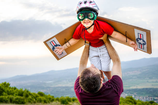 Father holding his little boy mid air while he pretends to fly