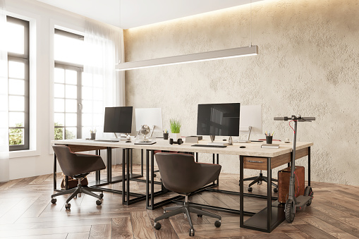 Open plan coworking interior with large desk, desktops, office supplies and  notebooks. Large concrete wall and wooden floor. Render.