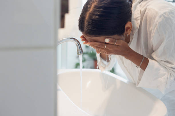 istock woman washing face at home 1433072601