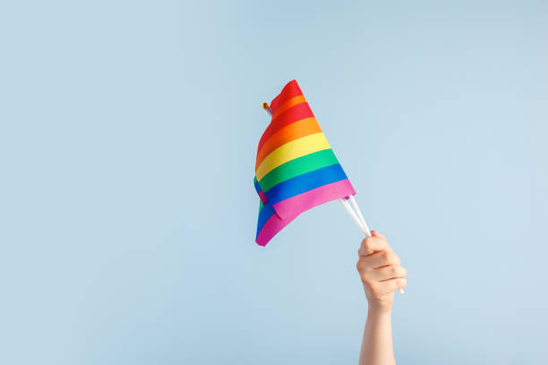 istock Gay flags in women's hand on grey background 1433073162
