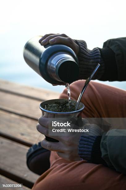 https://media.istockphoto.com/id/1433073206/photo/person-in-warm-clothes-pouring-water-from-flask-bottle-into-bowl-sitting-on-wooden-surface.jpg?s=612x612&w=is&k=20&c=-6SyjWLQvTG7q9JxGJ_PIbbtPUKj8PFBdj0Lq942vAY=