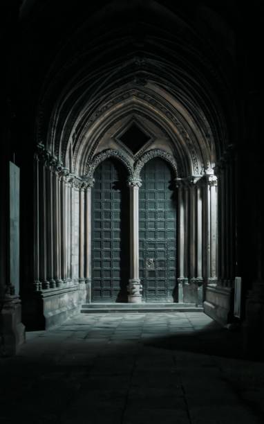 istock Dark Cathedral Arched wooden doors at night with light silouette 1433075120