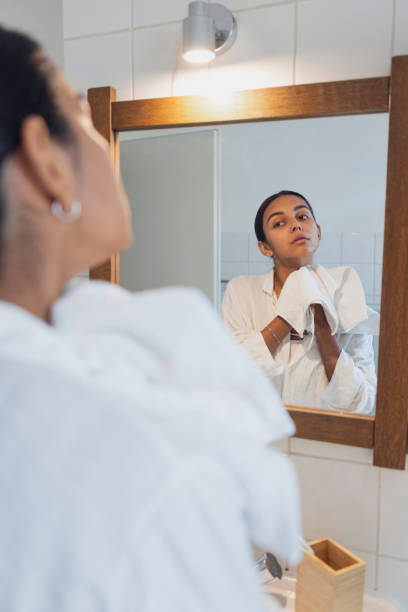 istock Young woman with towel looking in mirror at home 1433076106