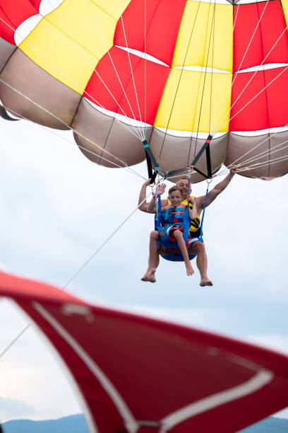 istock Father and son parasailing during summer day at sea 1433076933