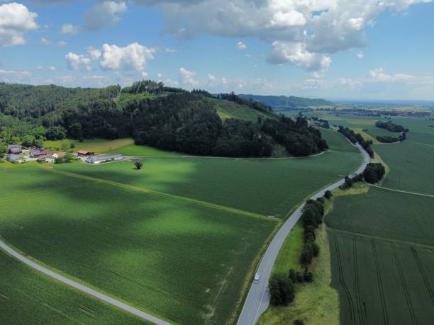 istock Drone shot over forested mountains and a village surrounded by green fields 1433076989