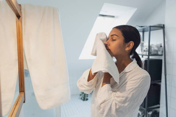 istock Young woman with towel looking in mirror at home 1433077197