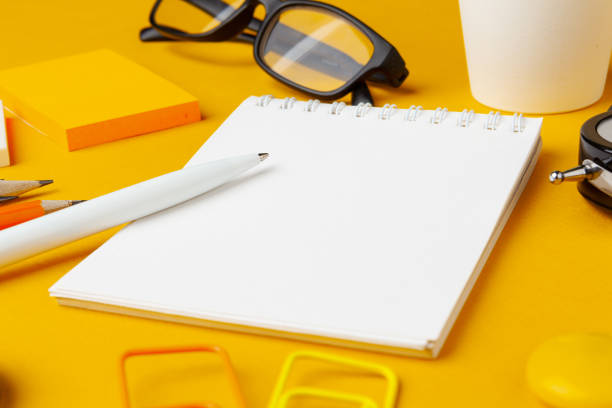 Stylish messy yellow desk top with various stationery top view