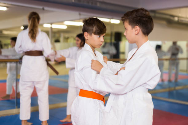istock Kids in kimonos exercising techniques in pair during taekwondo class at gym closeup 1433078114