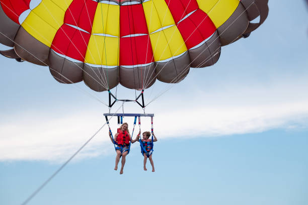 istock Mother and son parasailing during summer day at sea 1433078121