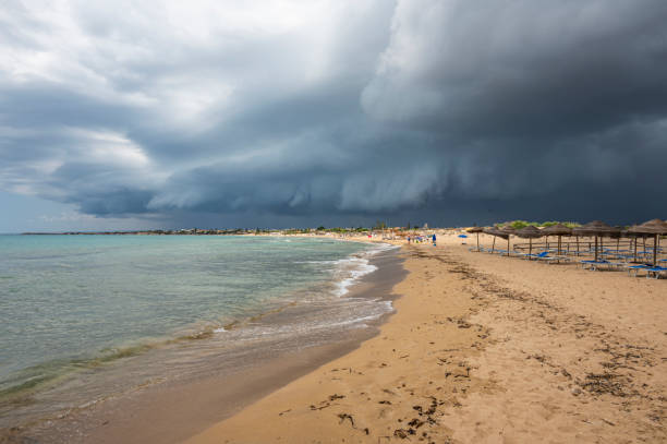 Beautiful sunny beach with black and stormy clouds in the sky in Sicily stock photo