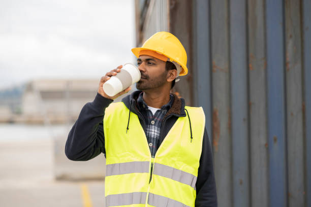 istock a man of Indian origin who works at a freight loading dock, drinking a coffee during his break. 1433081097