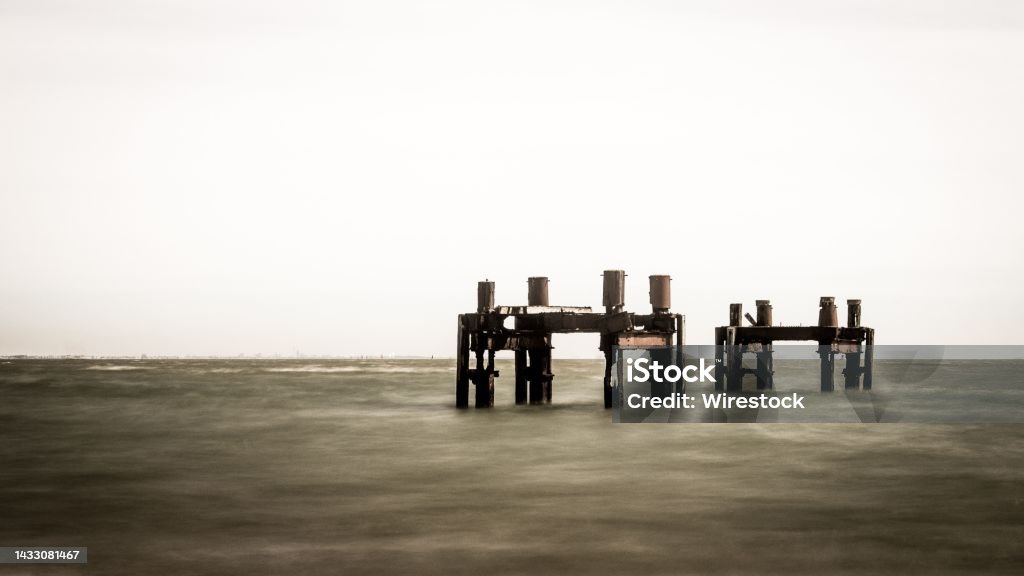 Wooden sea dock remains in the ocean of Calshot beach, Calshot, England, UK Old wooden sea dock remains in the ocean of Calshot beach, Calshot, England, UK Beach Stock Photo