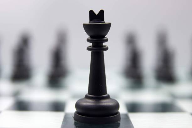istock Closeup of a black king standing on a chessboard on blurry background 1433081753
