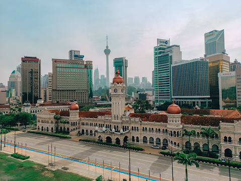 Aerial view of Merdeka Square and Sultan Abdul Samad Building in Kuala Lumpur, Malaysia, with the urban cityscape as ackground