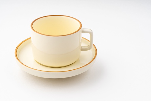 A Set of white and brown ceramic plate and cup on a white background