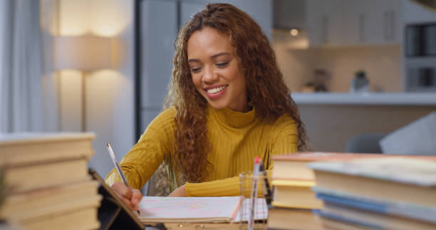 istock College student, young woman and studying, writing and reading textbooks for education test, exam research and assignment homework at night. Knowledge, university academics and learning late at home 1433085109