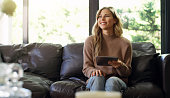 Relax woman on sofa with a tablet for social media app, live streaming film, movie or searching for online content with home internet wifi. Young blonde girl on a couch with fun digital technology