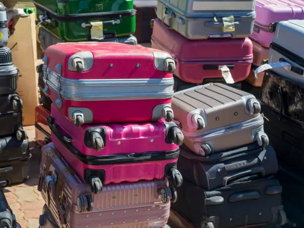 a pile of suitcases at lost and found department at the airport