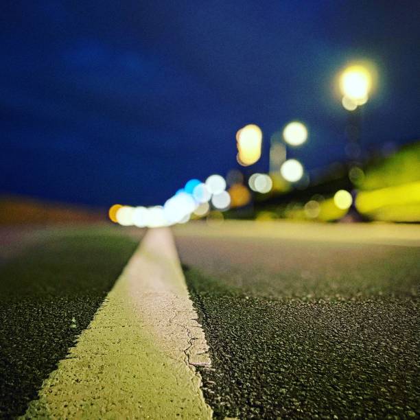 istock Yellow paint on the road with bokeh background 1433089621