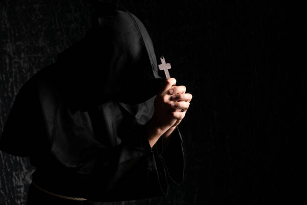 istock A monk praying with a rosary and crucifix in his hand. 1433089768