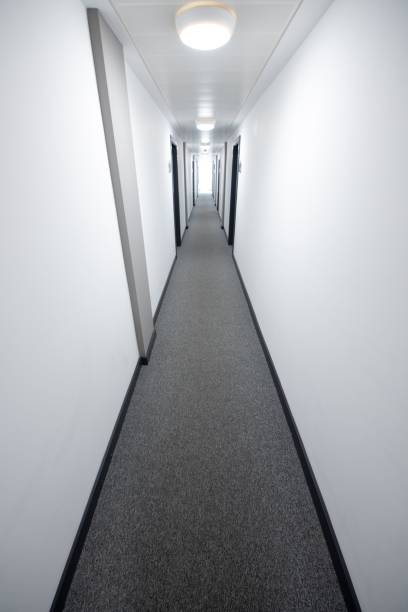 istock Vertical shot of a long, narrow white hallway in an apartment complex 1433090626