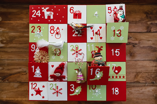wooden advent calendar with vintage decoration on wooden background