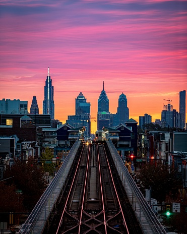 An aerial view of Benjamin Franklin Bridge and Philadelphia skyline on colorful sunset sky background