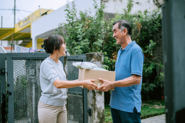 An Asian man donate some food to his neighbor stock photo