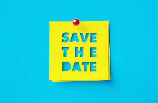 Save the date written cut out yellow adhesive notes sitting on blue background. Horizontal composition with copy space.
