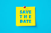 Save The Date Written Cut Out Yellow Adhesive Notes Sitting Over Blue Background