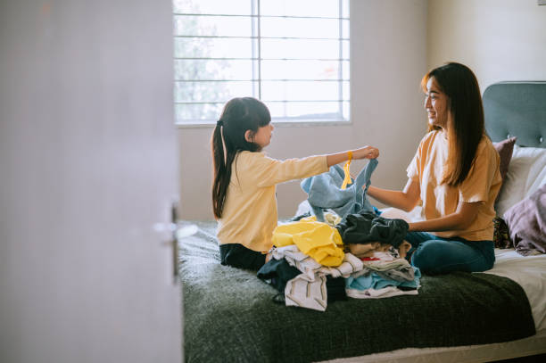 istock Mother and daughter preparing clothes for donating 1433095833