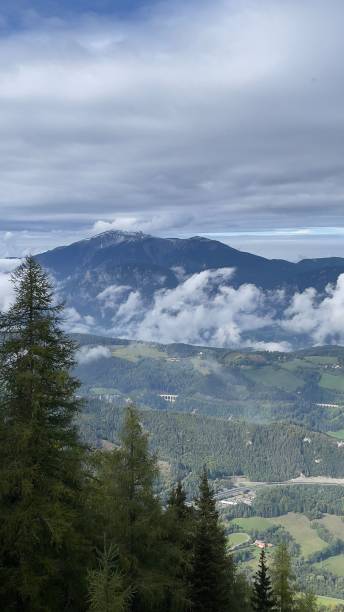 istock Vertical shot behind trees of mountains and cloudy sky in Austria 1433096008